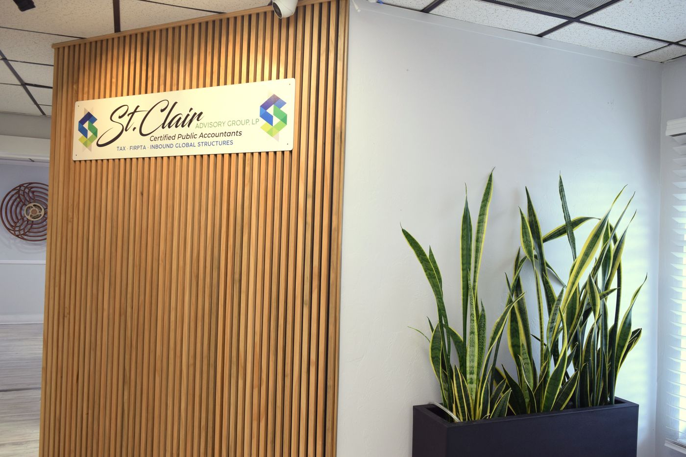 Reception wall with the St. Clair sign and a planter